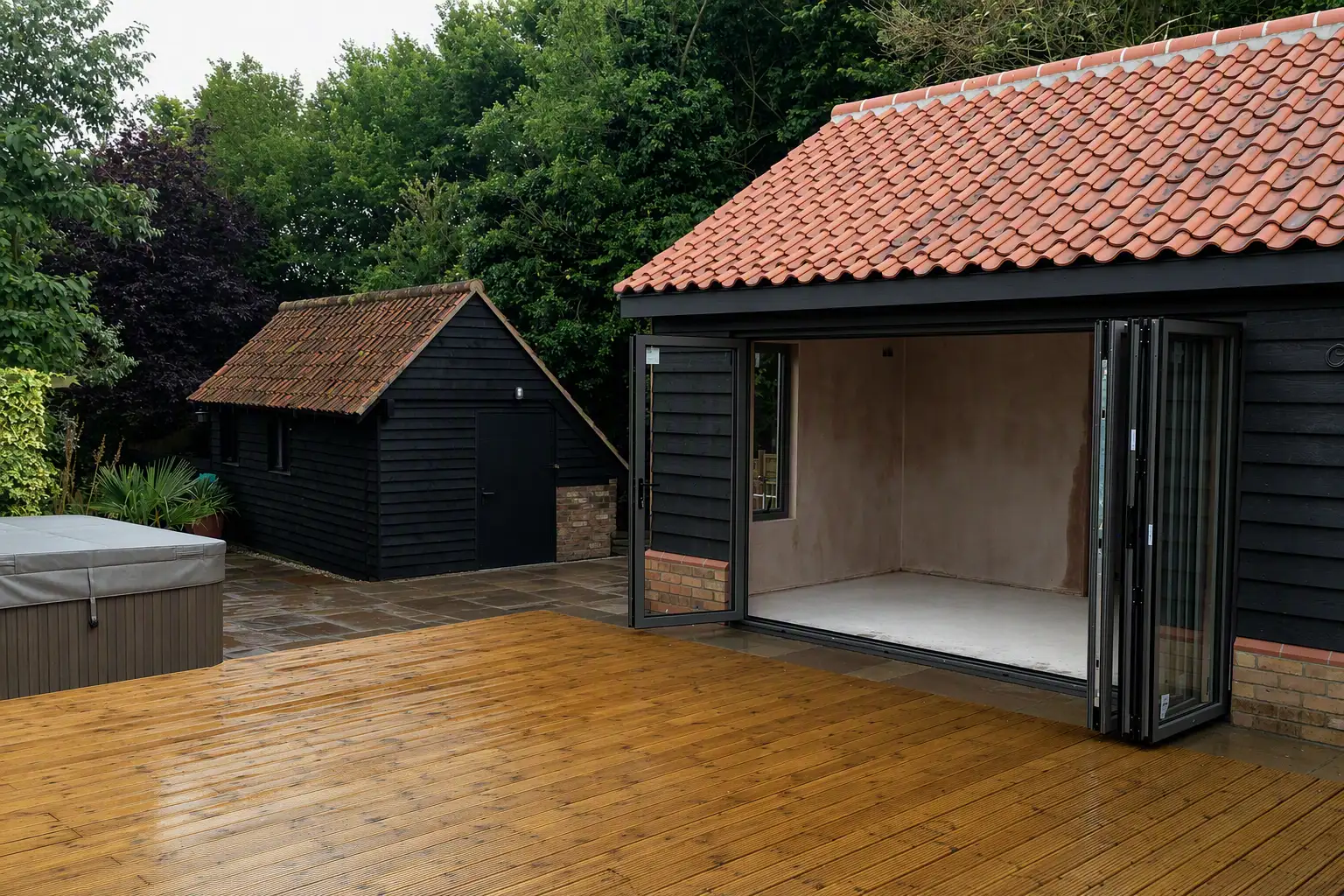 Clad garden room with the bi-folds open onto decking